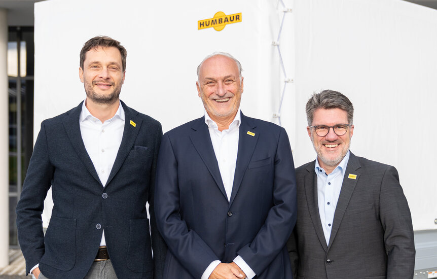 Humbaur Geschäftsführung | © Humbaur GmbH Drei Männer stehen vor einem Anhänger mit weißer Plane | © Humbaur GmbH