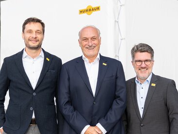 Humbaur Geschäftsführung | © Humbaur GmbH Drei Männer stehen vor einem Anhänger mit weißer Plane | © Humbaur GmbH