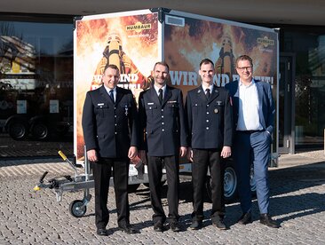 Humbaur Geschäftsführer Dr. Volker Nilles übergibt bedruckten Kofferanhänger an drei Vertreter des Stadtfeuerwehrverbands Augsburg. | © Humbaur GmbH