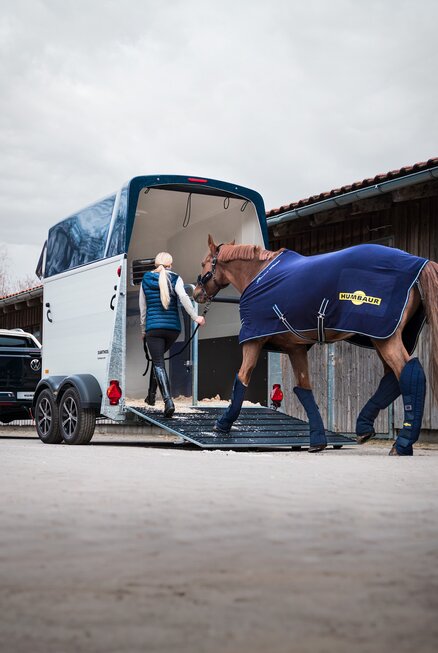 Frau führt Pferd in einen Humbaur Pferdeanhänger | © Humbaur GmbH